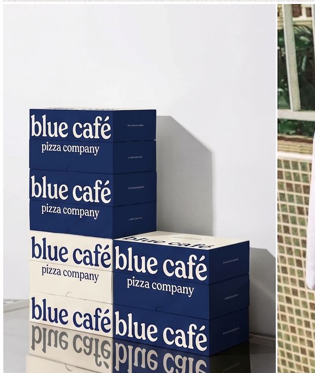 Gestapelde navy en crème pizzadozen met het Blue Café woordmerk